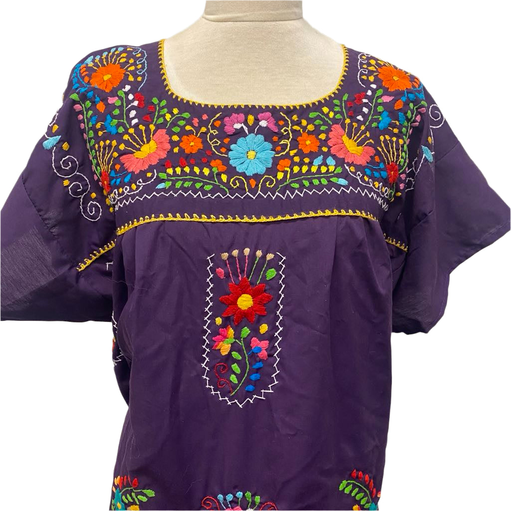 Purple blouse with colorful floral embroidery on a mannequin against a white background