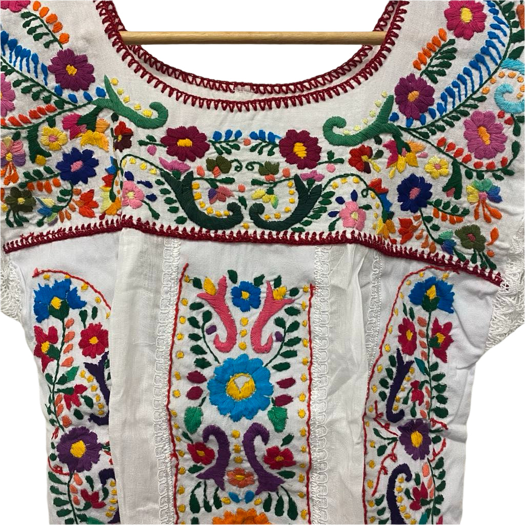 Colorful embroidered garment on a wooden hanger
