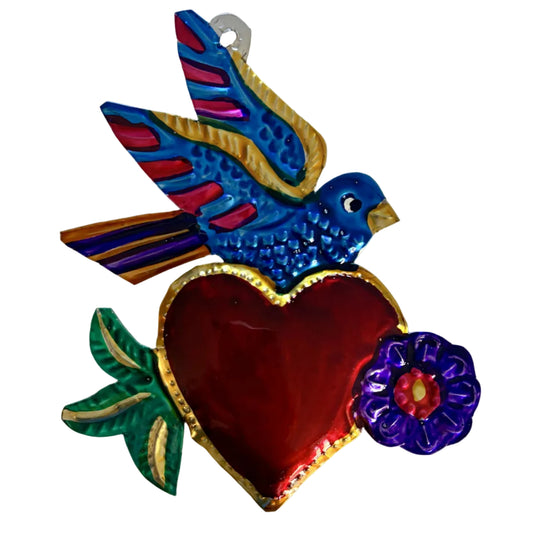 A colorful metal ornament featuring a blue bird with red and gold wings, perched on a large red heart with green leaves and a purple flower, set against a plain white background.