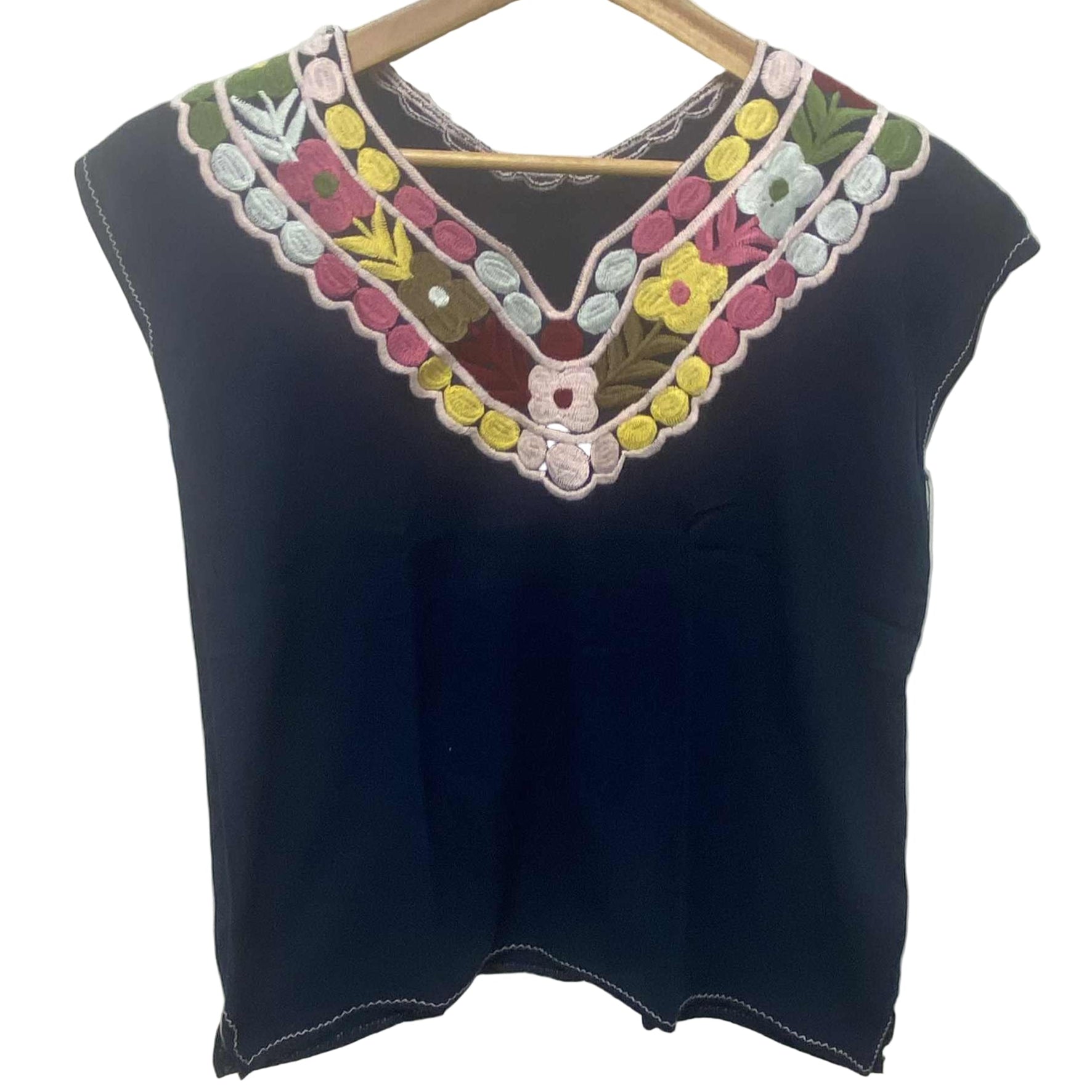 Black sleeveless top with colorful embroidered neckline on a hanger against a white background